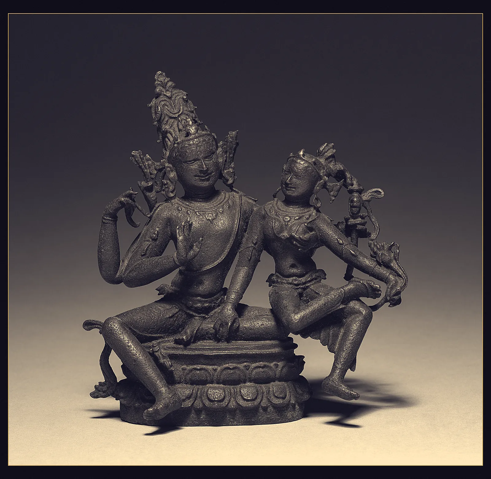 A small Pala bronze of Shiva and Parvati seated together on a lotus base, turned slightly towards each other